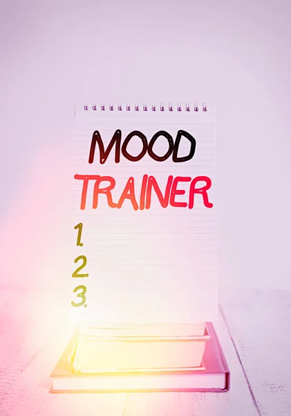 Scrittura concettuale a mano che mostra Mood Trainer. Business photo text a dimostrating who trains to alleviate mood disorders Anteriore vista stacked books spiral note book on vintage wooden table . — Foto Stock
