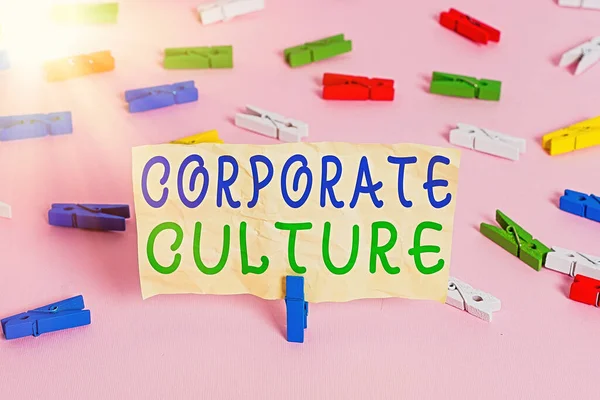 Text sign showing Corporate Culture. Conceptual photo pervasive values and attitudes that characterize a company Colored clothespin papers empty reminder pink floor background office pin.