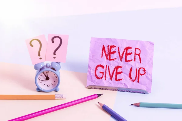 Textzeichen mit der Aufschrift Never Give Up. Konzeptionelle Foto beharrlich sein, um weiterhin versuchen, den Zustand zu verbessern Mini-Größe Wecker neben stationären platziert geneigt auf Pastell-Hintergrund. — Stockfoto