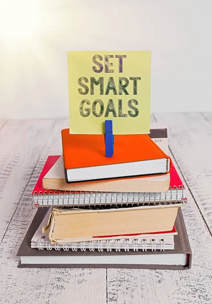 Text sign showing Set Smart Goals. Conceptual photo list to clarify your ideas focus efforts use time wisely pile stacked books notebook pin clothespin colored reminder white wooden. — Stock Photo, Image