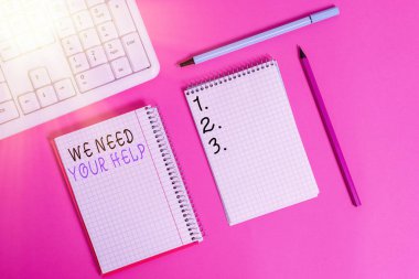 Yardımına ihtiyacımız olduğunu gösteren bir not yazıyorum. İş fotoğrafı sergisi. Renkli düz masa üzerine yerleştirilmiş ekipman ve bilgisayar malzemelerini yazma zorluğuna karşı birinin sizinle birlikte durmasını istiyor..