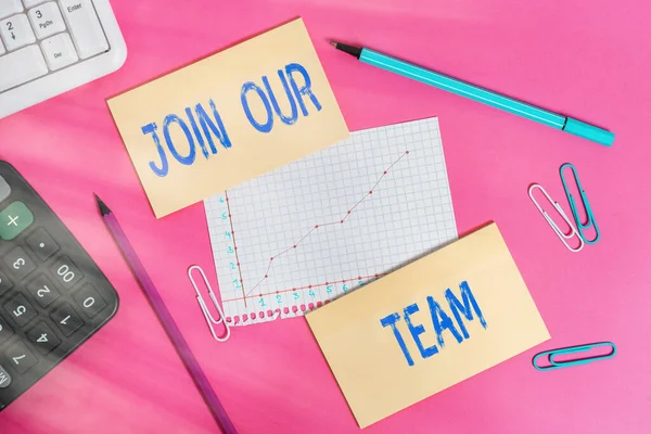 Writing note showing Join Our Team. Business photo showcasing inviting someone to join in your local group or company Writing equipments and computer stuffs placed above colored plain table.