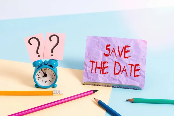 Text sign showing Save The Date. Conceptual photo Organizing events well make day special event organizers Mini size alarm clock beside stationary placed tilted on pastel backdrop. — Stock Photo, Image