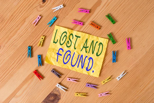 Escribiendo una nota mostrando Lost And Found. Foto de negocios mostrando un lugar donde los artículos perdidos se almacenan hasta que recuperaron papeles de pinza de ropa de colores vacía recordatorio piso de madera oficina de fondo . —  Fotos de Stock
