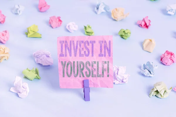 Ecriture conceptuelle montrant Invest In Yourself. Texte photo d'affaires nichant dans un entraîneur ou une formation pour apprendre de nouvelles choses Papiers froissés colorés rappel vide pinces à linge bleu . — Photo