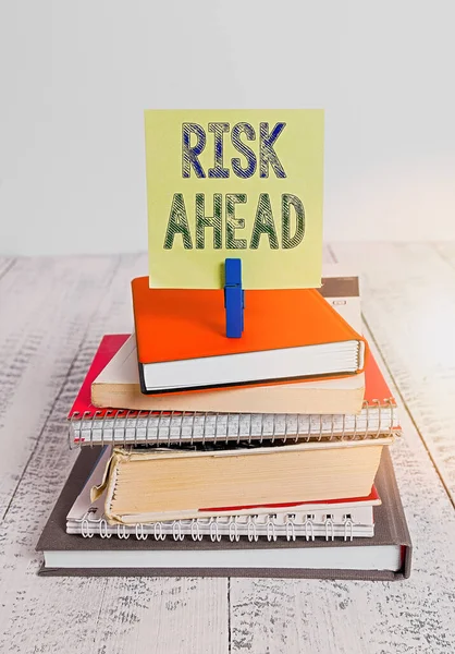 Text sign showing Risk Ahead. Conceptual photo A probability or threat of damage, injury, liability, loss pile stacked books notebook pin clothespin colored reminder white wooden. — Stock Photo, Image