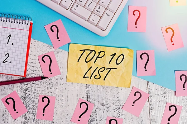 Writing note showing Top 10 List. Business photo showcasing the ten most important or successful items in a particular list Writing tools and scribbled paper on top of the wooden table.