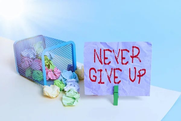 Writing note showing Never Give Up. Business photo showcasing be persistent to keep on trying to improve the condition Trash bin crumpled paper clothespin reminder office supplies.