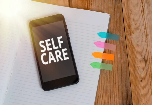 Writing note showing Self Care. Business photo showcasing the practice of taking action to improve one own health Striped note book colored arrow banners smartphone wooden background. — Stock Photo, Image