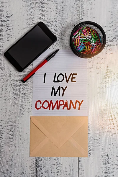 Escrevendo uma nota mostrando I Love My Company. Foto de negócios mostrando dizer por que admirar o seu trabalho e local de trabalho Smartphone clipes folha de papel caneta envelope de madeira vintage fundo . — Fotografia de Stock