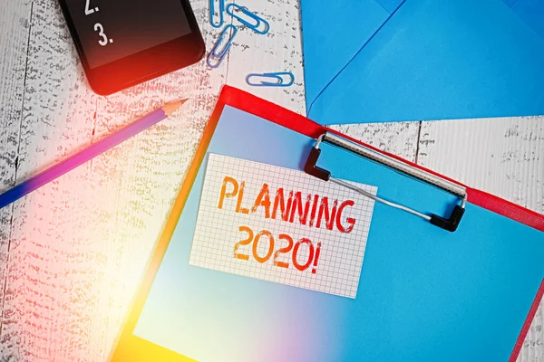 显示2020年规划的文字标志。为明年的事情制定计划的概念性照片制作过程剪贴板铅笔夹智能手机信封木制背景. — 图库照片