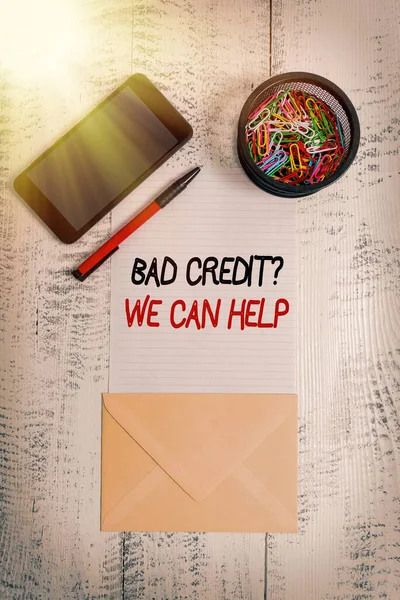 Writing note showing Bad Credit Question We Can Help. Business photo showcasing offering help after going for loan then rejected Smartphone paper sheet clips pen envelope wooden vintage background.