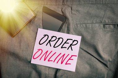 Order Online 'ı gösteren bir not yazıyorum. Pantolonun ön cebinde cüzdan bulunan internet akıllı telefon cihazı üzerinden ürün veya hizmet satın alma etkinliği.