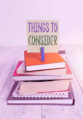 Düşünecek Şeyler gösteren metin işareti. Kavramsal fotoğraf, yığınla kitap, toka, toka, hatırlatıcı beyaz ahşap üzerine karar vermek için bir şeyi dikkatlice düşün..