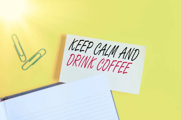 Escrevendo nota mostrando Mantenha a calma e beba café. Foto de negócios mostrando incentivar a desfrutar de bebida de cafeína e relaxar papel laranja vazio com espaço de cópia na mesa amarela . — Fotografia de Stock