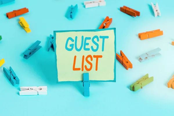Conceptual hand writing showing Guest List. Business photo showcasing a list of showing who are allowed to enter the show or an event Colored clothespin paper empty reminder blue floor officepin.