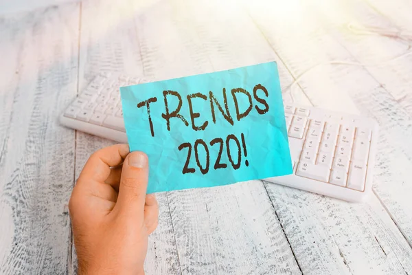 Word writing text Trends 2020. Geschäftskonzept für die allgemeine Richtung, in der sich etwas entwickelt oder verändert Mann hält bunte Erinnerung quadratische Papier weiße Tastatur Holzboden. — Stockfoto