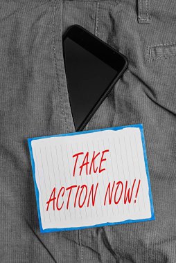 Take Action Now 'ı gösteren kavramsal el yazısı. İş fotoğrafı metni resmi ya da uyumlu bir şey yapın. Pantolonun içindeki akıllı telefon aygıtı ile ön cebinizdeki kağıdı hedefleyin..