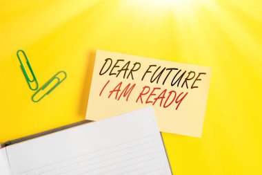 Sevgili Gelecek Ben Hazırım 'ı gösteren bir not yazıyorum. İş fotoğrafı durumu gösteriyor. Tamamen hazırlanmış. Sarı masada fotokopi alanı olan boş turuncu kağıt..