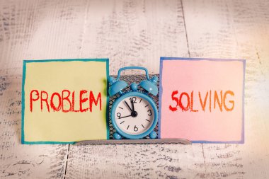 El yazısı problemi çözme. Zor ya da karmaşık sorunlara çözüm bulma süreci kavramının iki gösterim kağıdı arasında tampon telin üzerinde duran Mini mavi alarm saati.