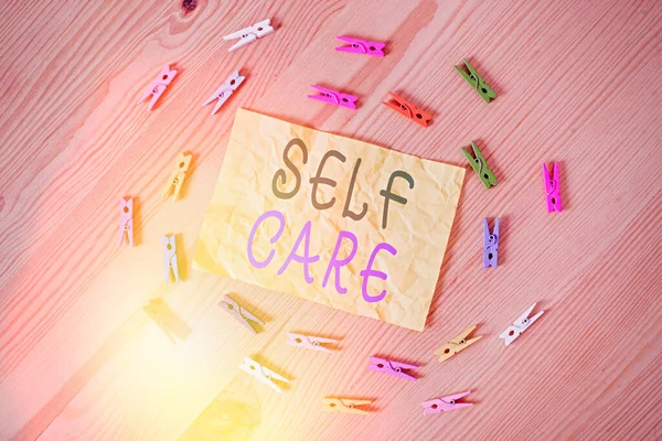 Writing note showing Self Care. Business photo showcasing the practice of taking action to improve one own health Colored clothespin papers empty reminder wooden floor background office. — Stock Photo, Image