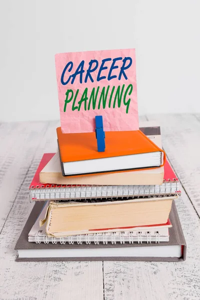 Word writing text Career Planning. Business concept for Strategically plan your career goals and work success pile stacked books notebook pin clothespin colored reminder white wooden.