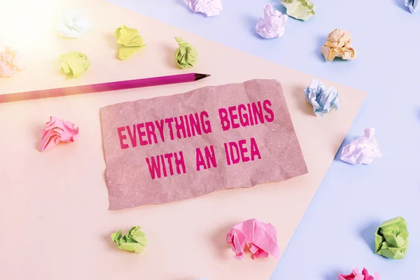 Text sign showing Everything Begins With An Idea. Conceptual photo steps you take to turn an idea into a reality Colored crumpled papers empty reminder blue yellow background clothespin. — Stock Photo, Image