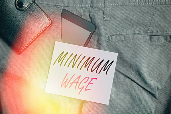 Writing note showing Minimum Wage. Business photo showcasing the lowest wage permitted by law or by a special agreement Smartphone device inside trousers front pocket with wallet.