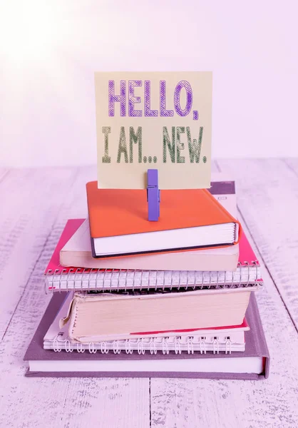 Sinal de texto mostrando Olá eu sou novo. Foto conceitual introduzindo-se em um grupo como trabalhador fresco ou estudante pilha empilhados livros caderno pin clothespin colorido lembrete branco de madeira . — Fotografia de Stock