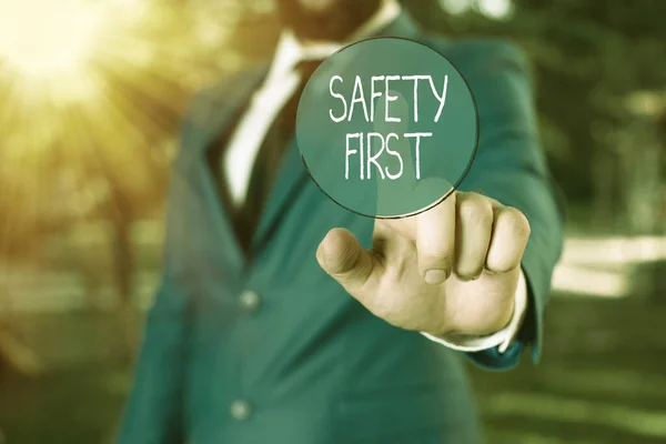 Word writing text Safety First. Business concept for used to say that the most important thing is to be safe Businessman with pointing finger in front of him.