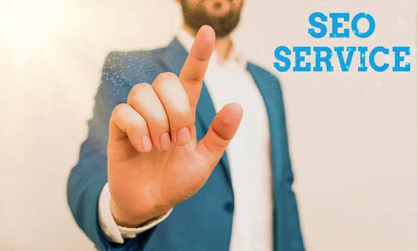 Schrijfbriefje met Seo Service. Zakelijke foto presentatie technieken en procedures om de website zichtbaarheid Zakenman met wijzende vinger voor hem te verhogen. — Stockfoto