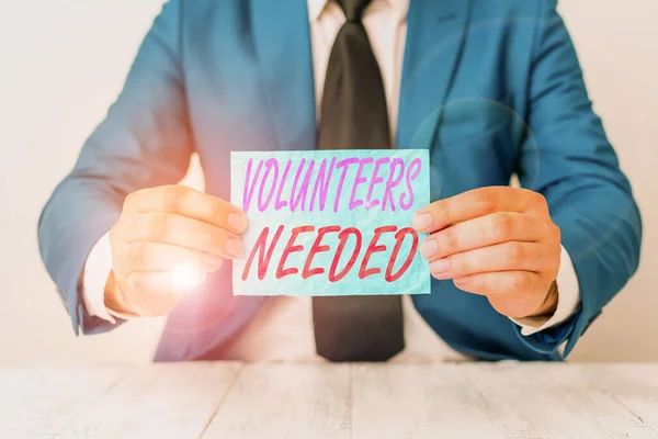 Handwriting text Volunteers Needed. Concept meaning need work or help for organization without being paid Man holds empty paper with copy space in front of him Copy Space.