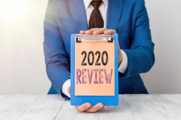 Kavramsal el yazısı 2020 Review 'i gösteriyor. İş fotoğrafı metni. 2020 Adam için turizm ve hizmetlerde yeni eğilimler ve beklentiler önünde kopya alanı olan boş bir kağıt tutuyor.. — Stok fotoğraf