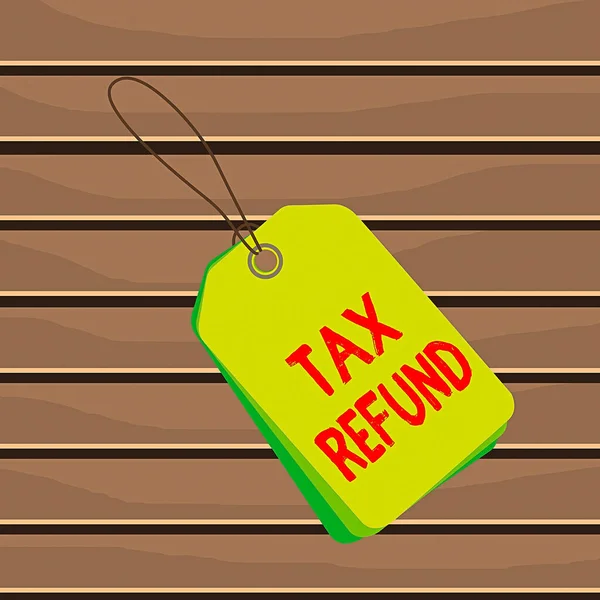 Conceptual hand writing showing Tax Refund. Business photo text refund on tax when the tax liability is less than the tax paid Rectangle badge attached string colorful background with tag.