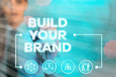 Markanızı İnşa Edin 'i gösteren bir not yazıyorum. Reklam kampanyaları kullanarak marka eşitliğini arttıran iş fotoğrafları..