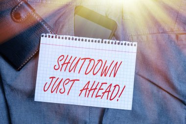 El yazısı metni: Kapatma Sadece İleride. Konsept, fabrika işinin ya kısa sürede ya da sonsuza kadar kapanması demek. Pantolonun ön cebindeki akıllı telefon cihazı, cüzdan ve not kağıdı..