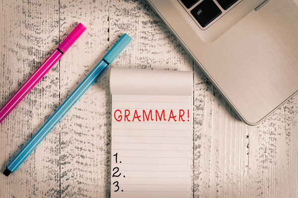 Conceptual hand writing showing Grammar. Business photo text whole system structure language syntax and morphology Trendy laptop blank ruled notepad pens lying wooden vintage table.