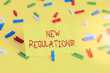 Yeni Yönetmelikler 'in el yazısı metinleri. Kural kavramının anlamı, hükümetin bir şeyi kontrol etmesini sağladı. Renkli çamaşır iğnesi kağıtları boş hatırlatıcı sarı zemin arka plan ofisi..