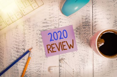 Metin işareti 2020 Review 'i gösteriyor. 2020 teknolojik cihaz için turizmde ve hizmetlerde yeni eğilimler ve beklentiler anımsatıcı kağıt ofis klavye faresini besliyor.