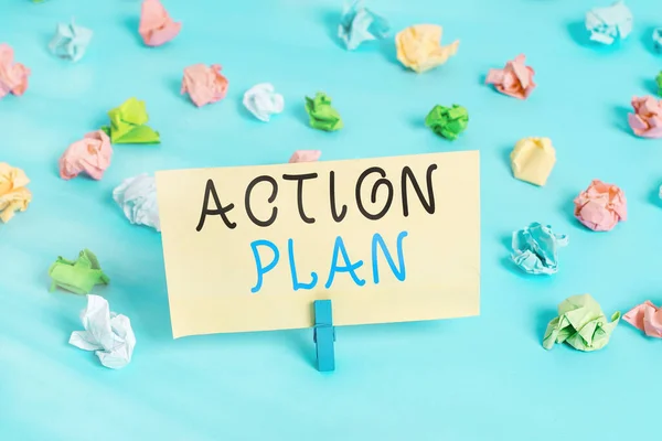 Handwriting text writing Action Plan. Concept meaning detailed plan outlining actions needed to reach goals or vision Colored crumpled papers empty reminder blue floor background clothespin.