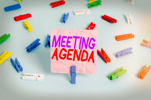 Handschriftlicher Text Meeting Agenda. Konzept bedeutet, dass Gegenstände, die Teilnehmer hoffen, bei einem Treffen zu erreichen Farbige Wäscheklammern Papiere leer Erinnerung blauer Boden Hintergrund Büro-Pin. — Stockfoto