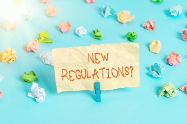 Kelime yazma metni Yeni Yönetmelik Sorusu. Kurallar için iş kavramı hükümetin düzen denetimini sağlar bir şeyler yapılır Renkli buruşuk kağıtlar boş hatırlatıcı mavi zemin çamaşır mandalı.