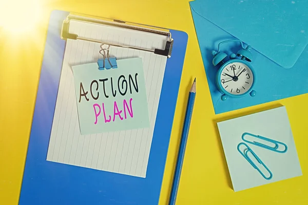 Word writing text Action Plan. Business concept for detailed plan outlining actions needed to reach goals or vision Clipboard sheet note binder pencil clips clock envelop colored background.