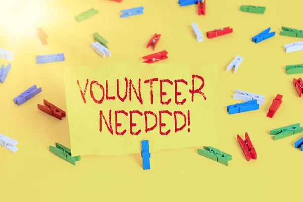 Handwriting text writing Volunteer Needed. Concept meaning need work for organization without being paid Colored clothespin papers empty reminder yellow floor background office.