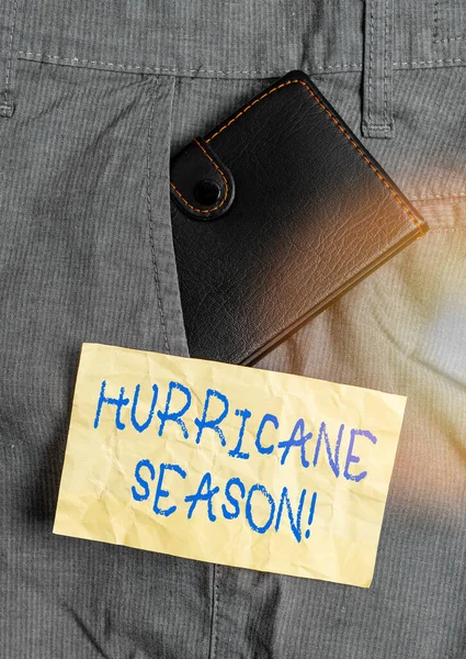 Word writing text Hurricane Season. Business concept for time when most tropical cyclones are expected to develop Small little wallet inside man trousers front pocket near notation paper.