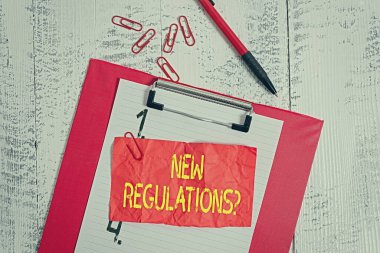 Yeni Yönetmelik Sorusu 'nu gösteren metin işareti. Kavramsal fotoğraf kuralları devlet düzenini kontrol altına aldı. Bir şeyler yapılıyor. Pano kağıtları, tükenmez kalemler, ezilmiş eski model arka planlar..