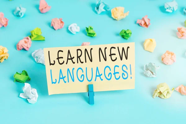Kézírás szövegírás Tanulj új nyelveket. Koncepció jelentése fejlődő képesség kommunikálni idegen nyelven Színes gyűrött papírok üres emlékeztető kék padló háttér ruhaszárító. — Stock Fotó