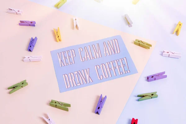 Skriva lapp som visar Behåll lugnet och drick kaffe. Business photo showcasing uppmuntra demonstrera att njuta av koffein dryck och koppla av färgad klädnypa papper påminnelse med gul blå bakgrund. — Stockfoto