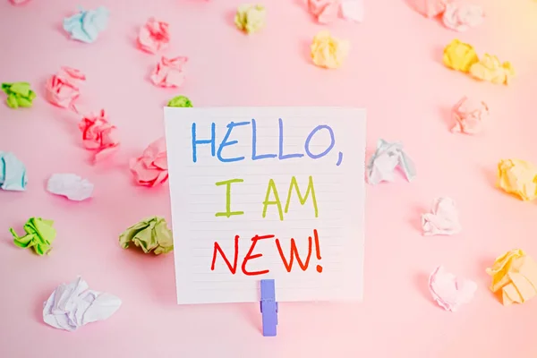 Conceptual hand writing showing Hello I Am New. Business photo showcasing introducing oneself in a group as fresh worker or student Colored crumpled papers empty reminder pink floor clothespin.