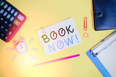 Book Now 'ı gösteren bir not yazıyorum. İş fotoğraflarının gösterileceği kesin, çünkü çoktan satın almışsınız. Alarm saati, pano hesap makinesi, cüzdan, bant kağıdı, ezilmiş kalem kağıdı..